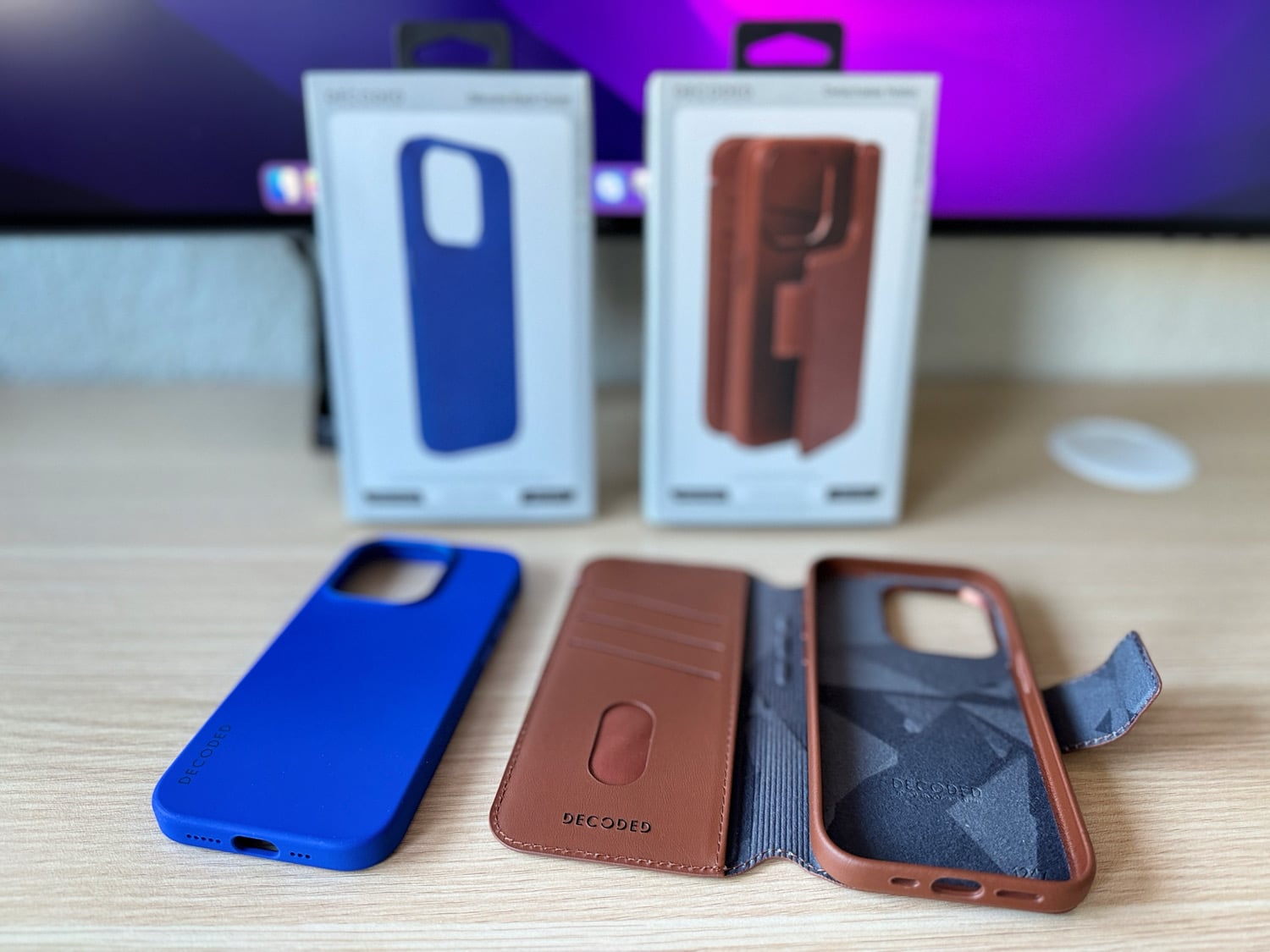 Decoded Cases aus braunem Leder und blauem Silikon mit Verpackung auf einem Schreibtisch