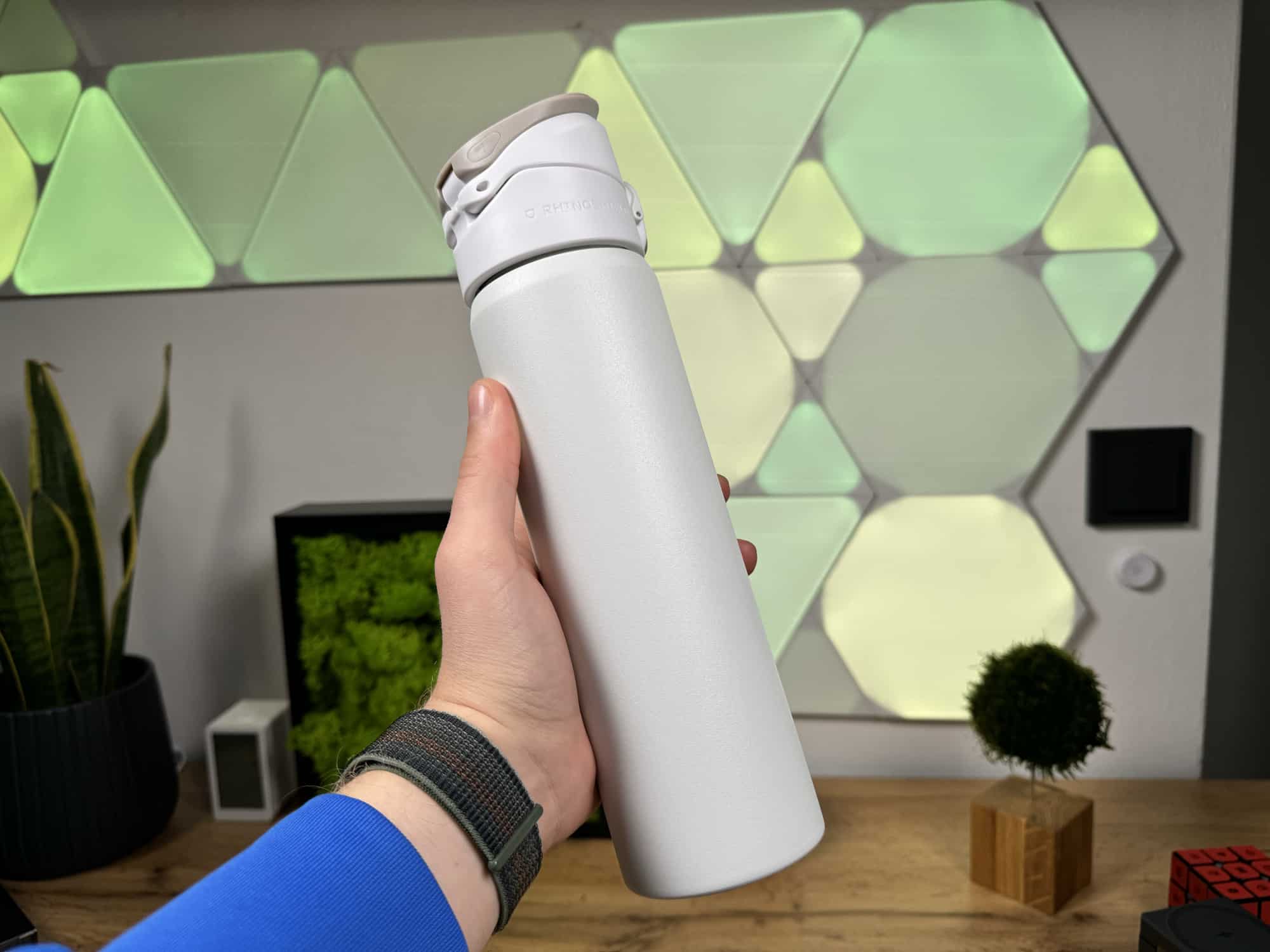 Rhinoshield AquaStand mit MagSafe Trinkflasche in der Hand haltend