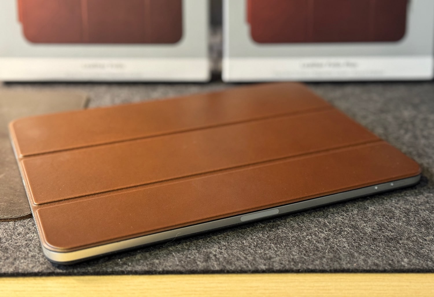 Braunes Nomad Leather Folio auf einem Schreibtisch mit Verpackungen im Hintergrund