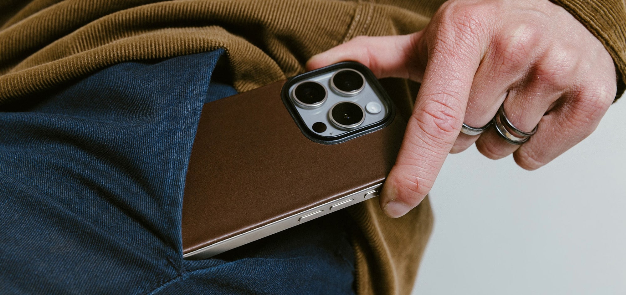 iPhone mit Nomad Magnetic Leather Back halb aus einer Hosentasche guckend
