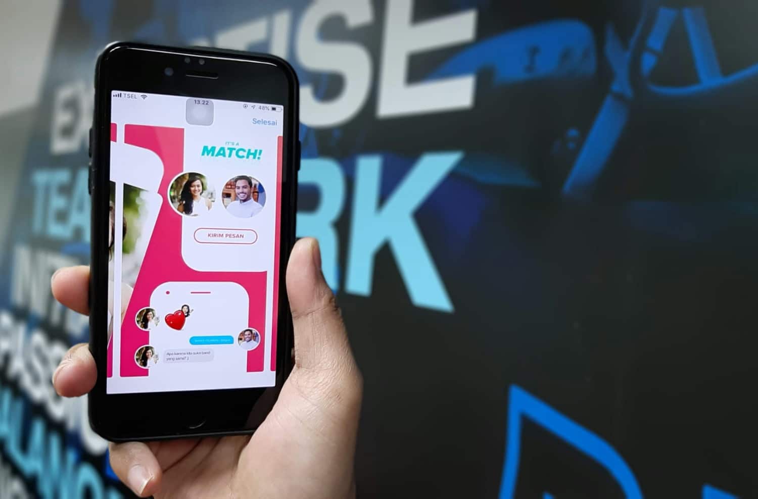 Eine Person hält ein iPhone in der Hand, auf dem ein Tinder-Match angezeigt wird