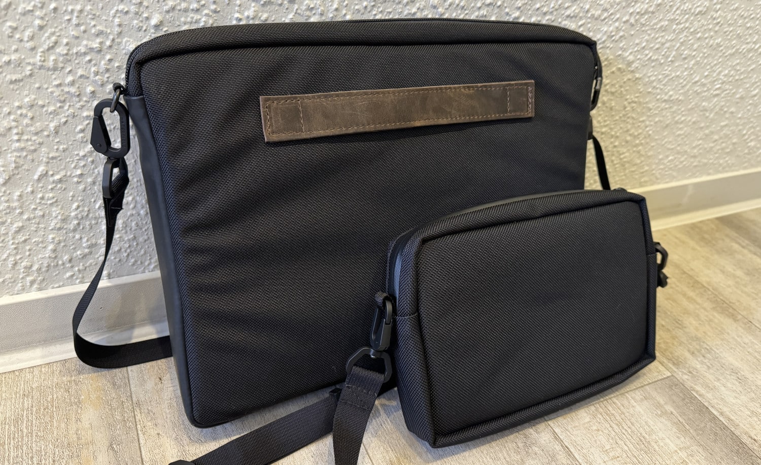 Rückseiten des WaterField Mason Crossbody und EDC Pouch vor einer Wand auf dem Boden