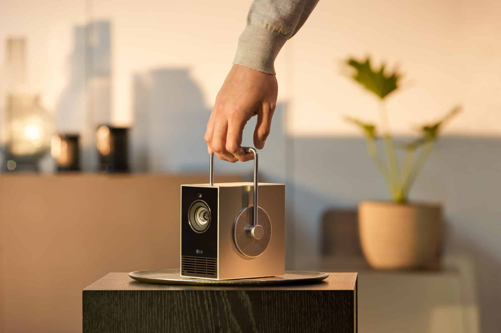 LG CineBeam Q Beamer wird mit einer Hand getragen