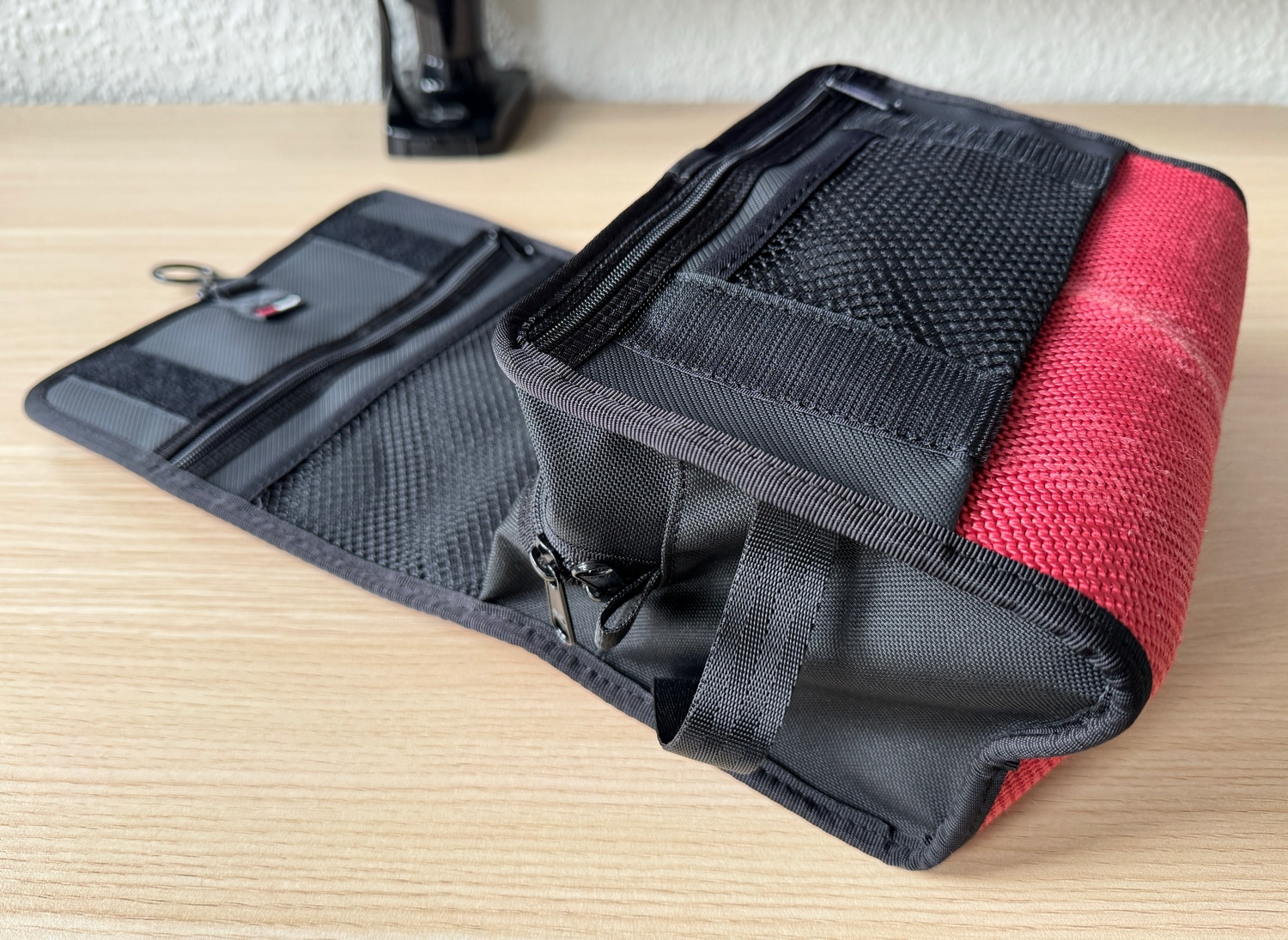 Aufgeklappter Feuerwear Henry-Kulturbeutel in Rot auf einem Schreibtisch