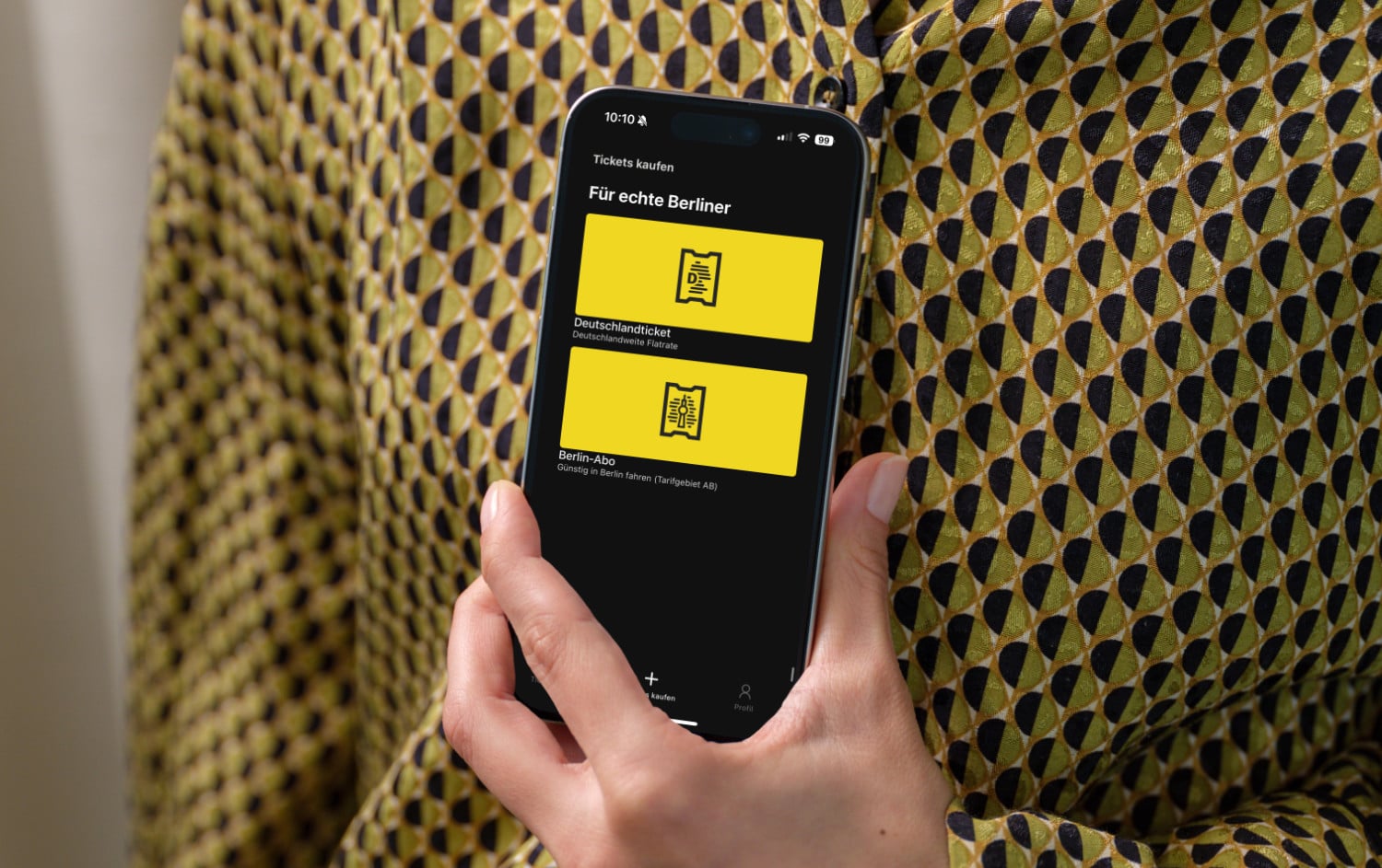 Eine Person hält ein iPhone mit geöffneter BVG Tickets-App in der Hand