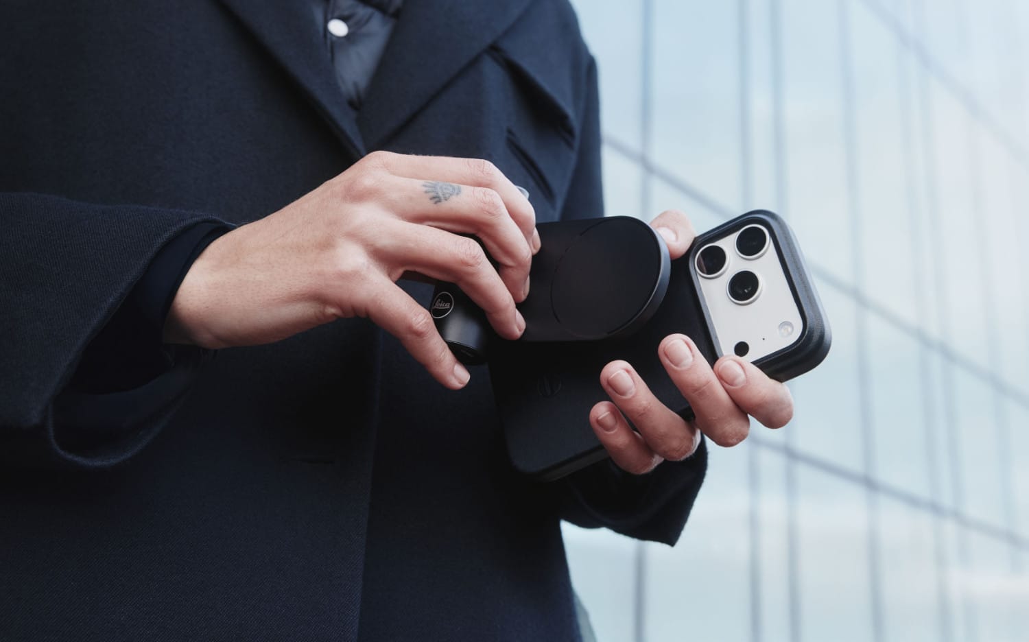 Eine Person bringt den LUX Grip an einem iPhone mit dem Leica LUX Case an